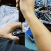 Technicus voert een testbanktest uit op een voertuigspecifiek digitaal instrumentenpaneel tijdens een garantiecontrole